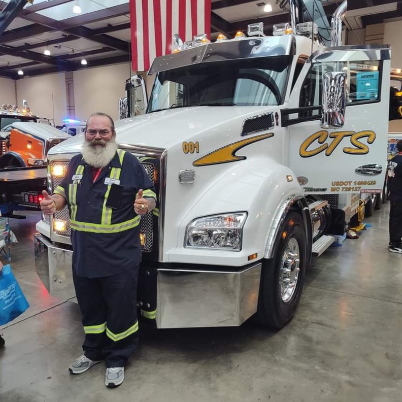 worker in front of tow truck