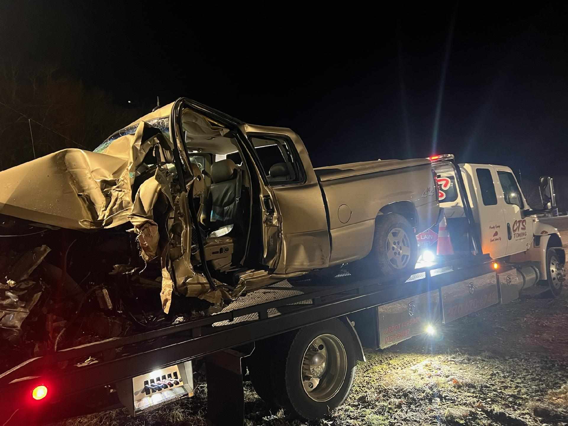wrecked pickup truck on towing truck