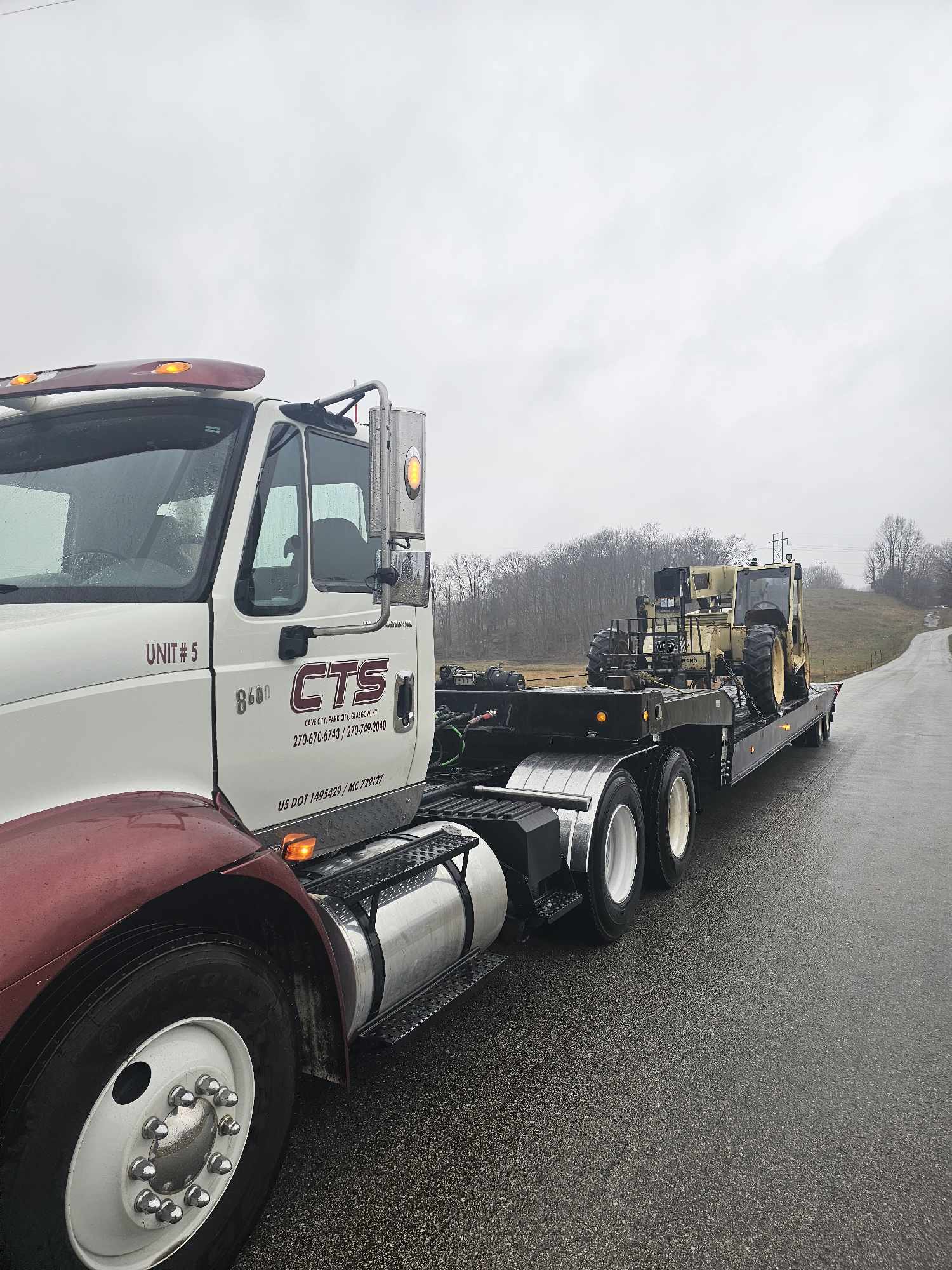tow truck hauling heavy farm machine