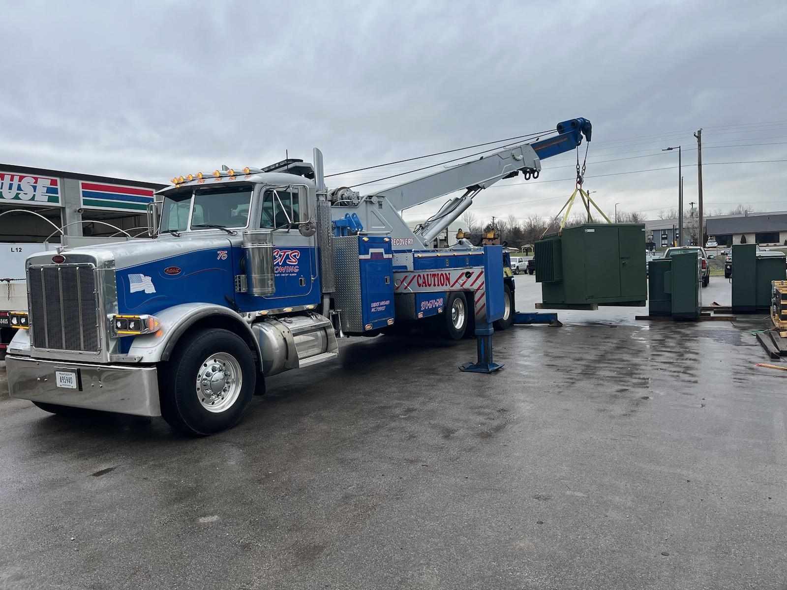 crane tow truck lifting large heat/air unit