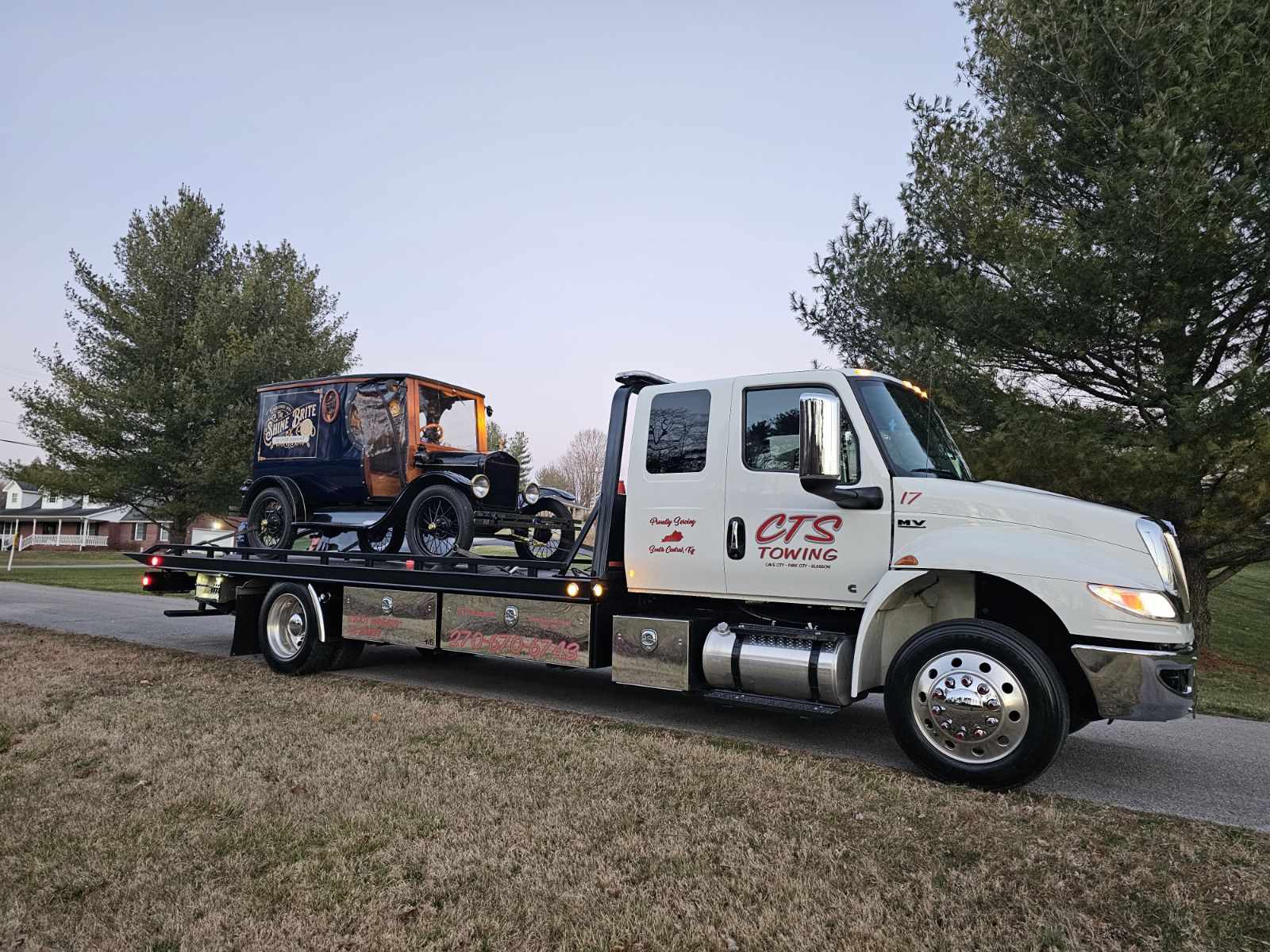 light towing truck hauling antique car