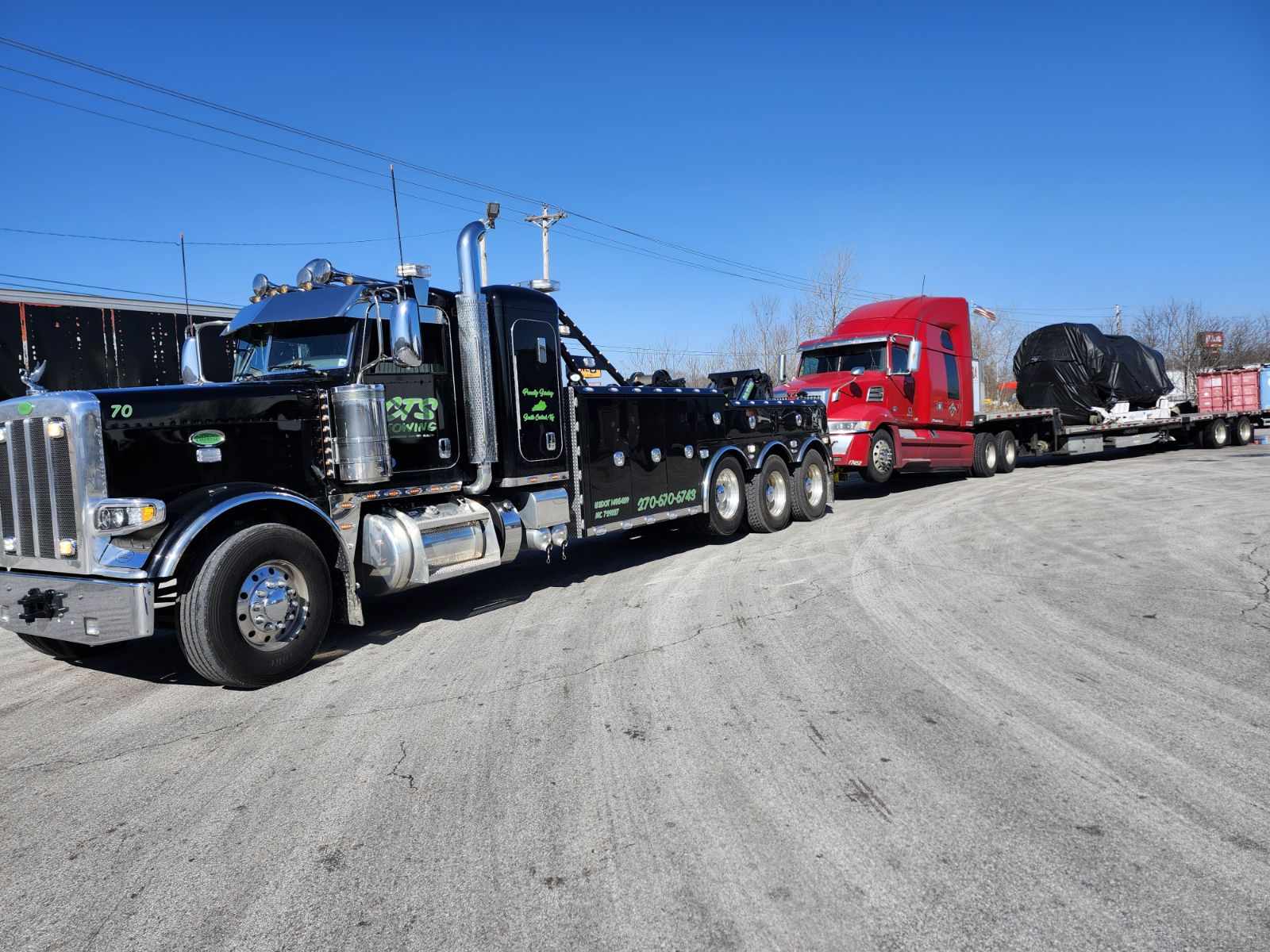 tow truck pulling semi truck with it loaded